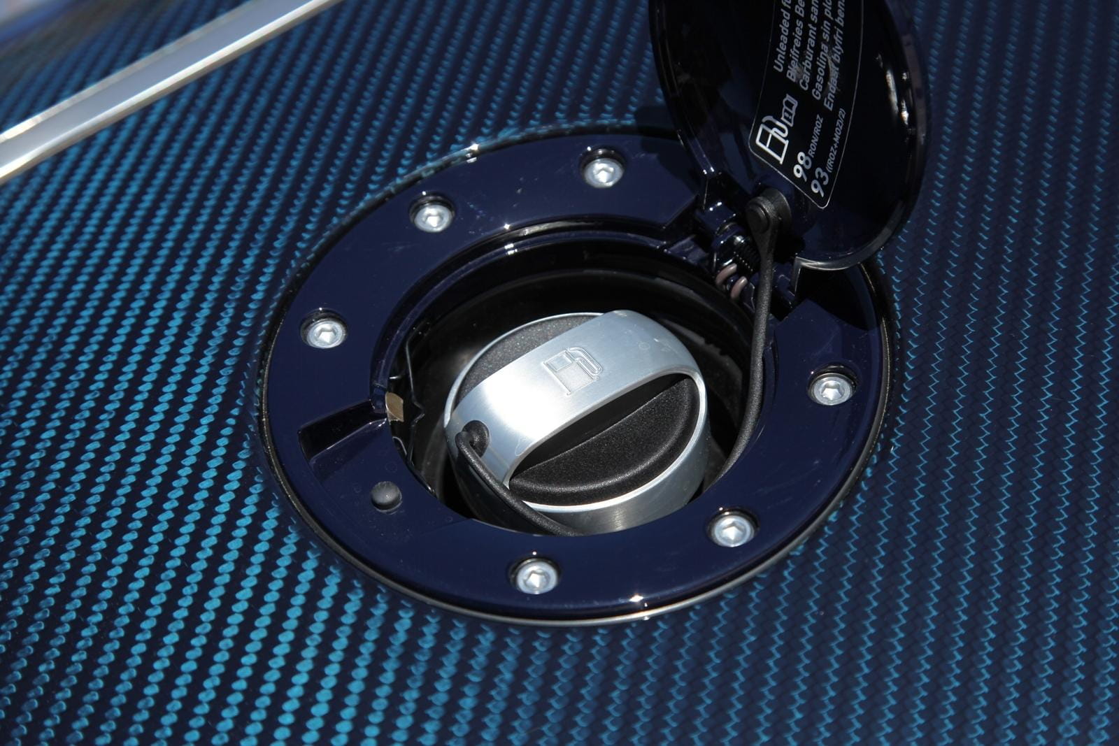 Toma de combustible del Bugatti Veyron con acabado metalizado y tornillería visible.
