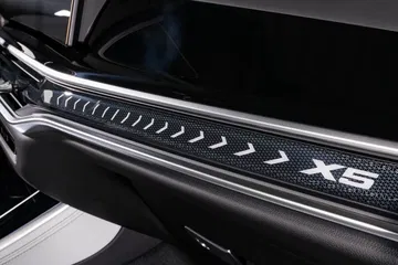 Vista de los controles de puerta y distintivo X5 iluminado.