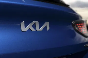 Detalle emblemático del logotipo de Kia en la carrocería lateral.