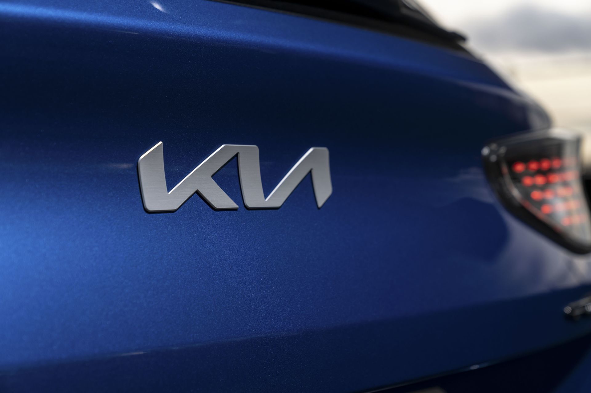 Detalle emblemático del logotipo de Kia en la carrocería lateral.