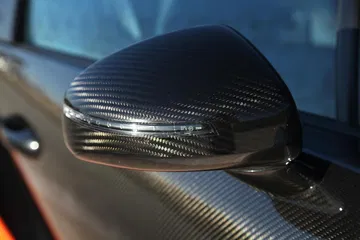 Vista cercana del espejo retrovisor del Bugatti Veyron con acabado en fibra de carbono.