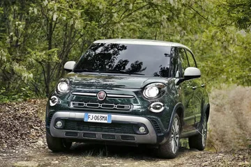 Fiat 500L en contexto de ruta boscosa, vista frontal y lateral.