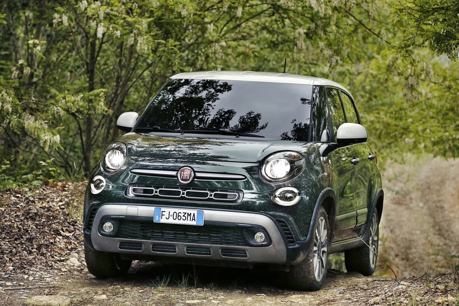 Fiat 500L en contexto de ruta boscosa, vista frontal y lateral.