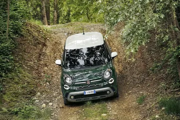 Vista delantera y lateral del Fiat 500L sobre camino forestal