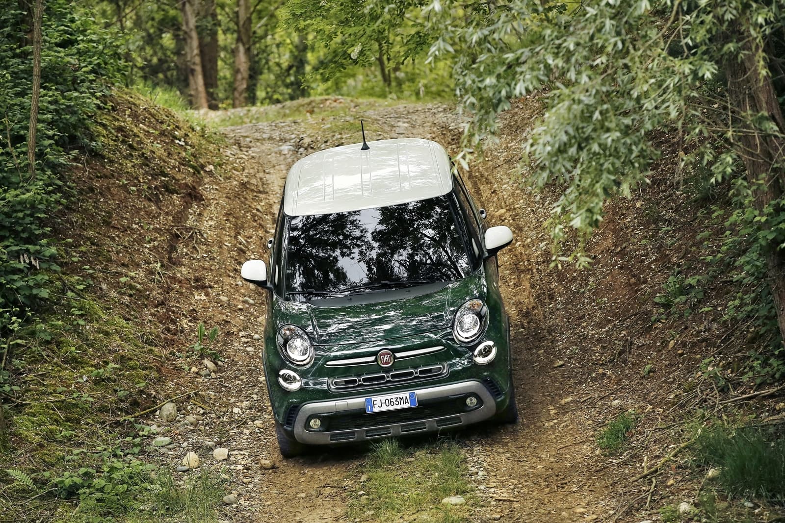Vista delantera y lateral del Fiat 500L sobre camino forestal