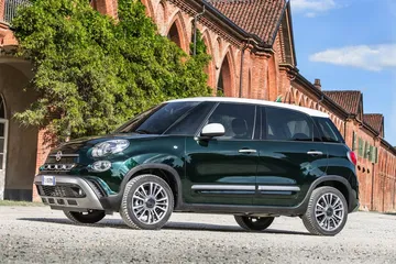 Vista lateral del Fiat 500L en un contexto urbano, destacando su diseño compacto.