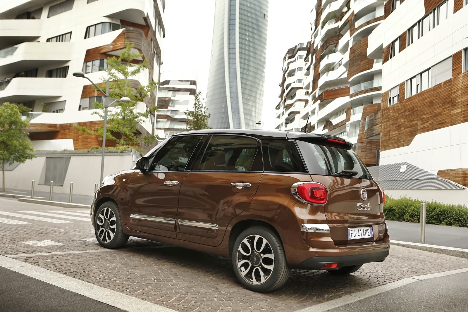 Vista lateral del Fiat 500L en un entorno urbano, destacando su diseño compacto.