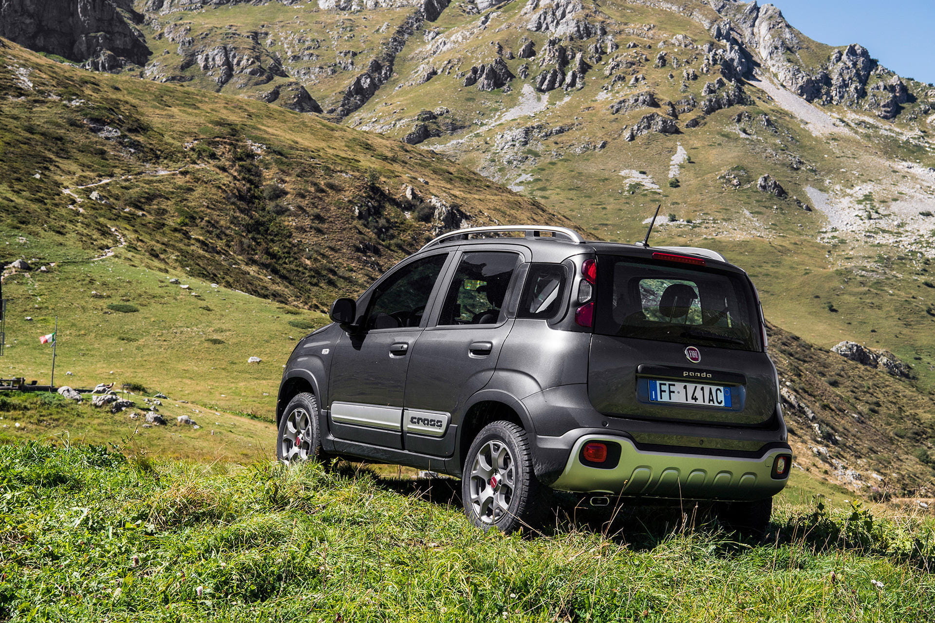 Vista trasera lateral del Fiat Panda en un entorno de montaña, destacando su diseño compacto y versátil