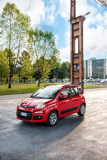 Vista lateral del Fiat Panda en un escenario urbano, destacando su diseño compacto.