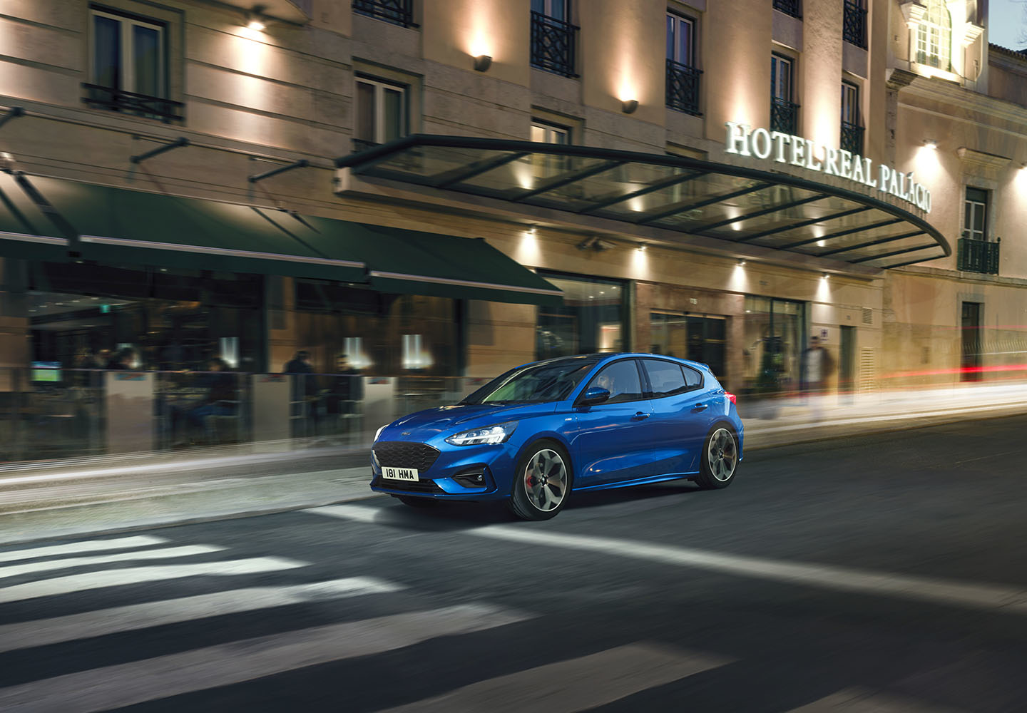 Ford Focus azul en movimiento nocturno, elegancia urbana.