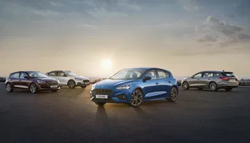 Flota Ford Focus al amanecer, destacando el modelo con acabado azul.