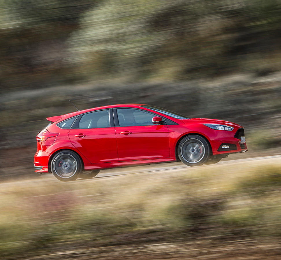 Vista dinámica lateral del Ford Focus en movimiento. Colores vivos y diseño deportivo.