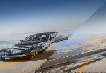 Ford Kuga en movimiento mostrando su perfil y parte frontal.