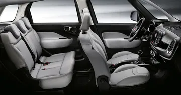 Vista lateral de la fila trasera de asientos del Fiat 500L, destacando su amplitud.