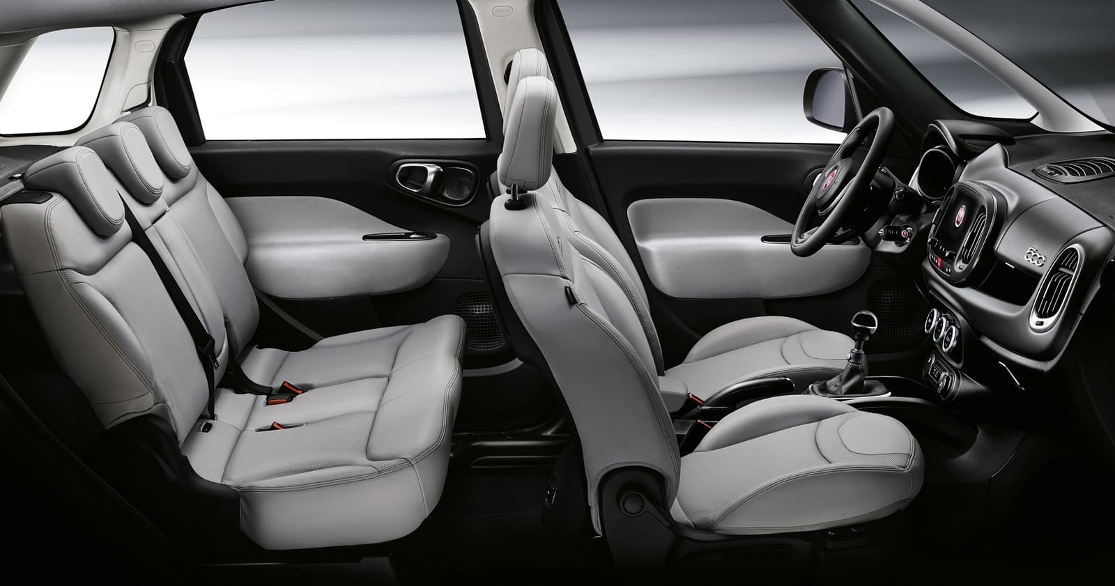 Vista lateral de la fila trasera de asientos del Fiat 500L, destacando su amplitud.