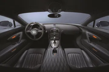 Vista del lujoso habitáculo del Bugatti Veyron, con asientos de cuero y acabados de carbono.
