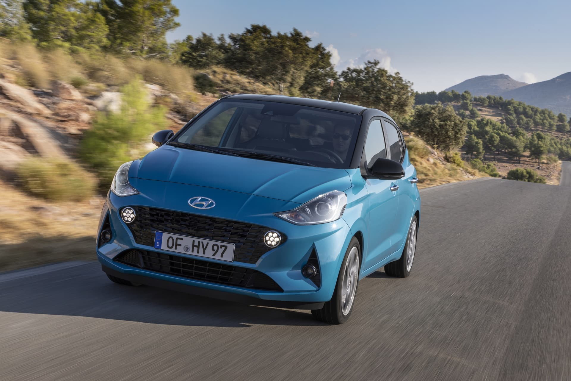 Vista dinámica del Hyundai i10 en carretera resaltando su diseño frontal y lateral.