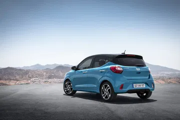 Vista dinámica lateral del Hyundai i10 en entorno desértico, exponiendo líneas y diseño.