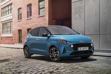 Vista lateral y delantera del Hyundai i10, mostrando su diseño urbano compacto.