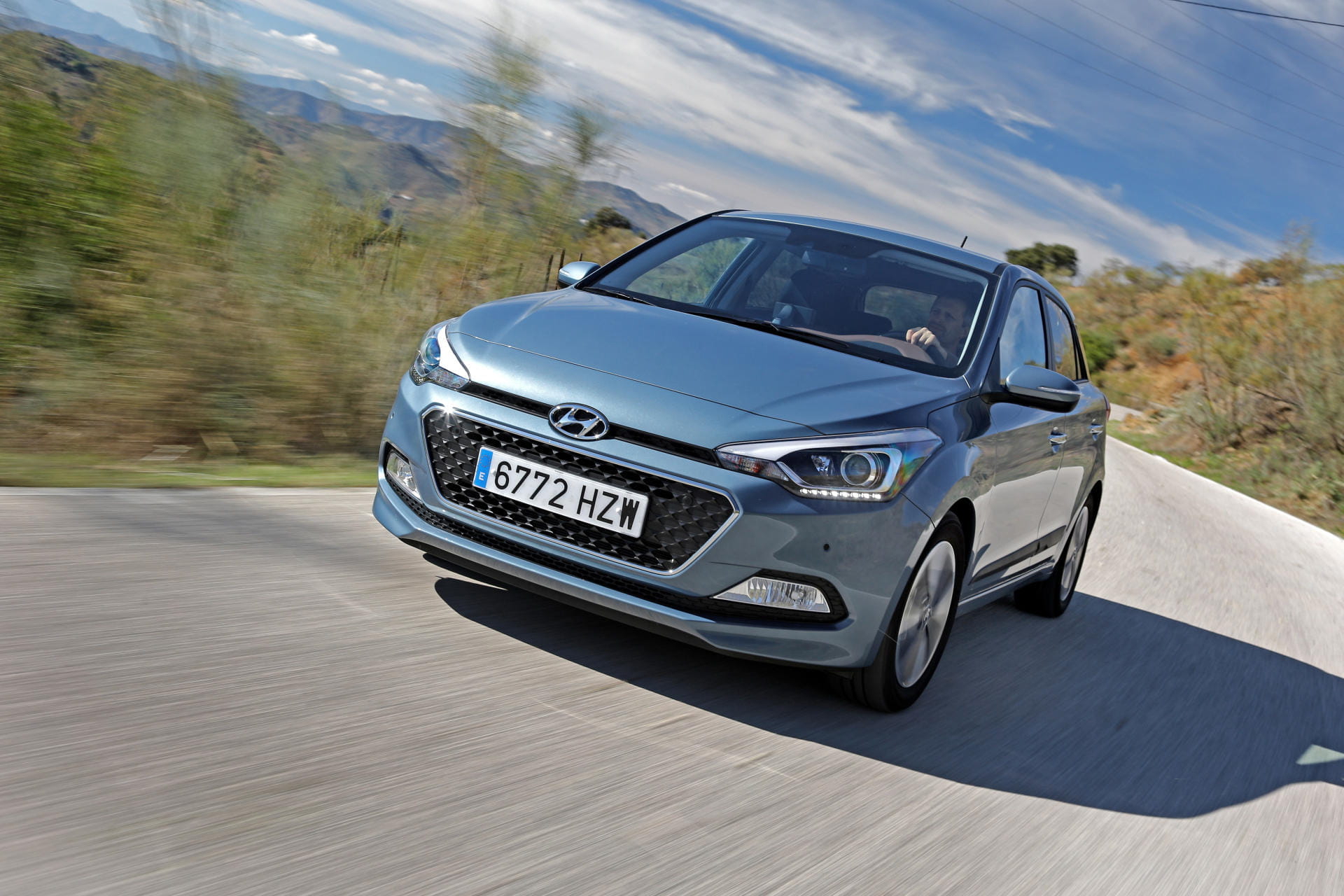 Vista de un Hyundai i20 en movimiento, destacando su diseño frontal y perfil.