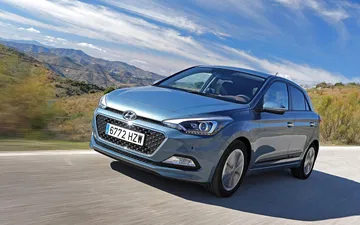 Vista dinámica del Hyundai i20 en carretera, destacando su diseño frontal.