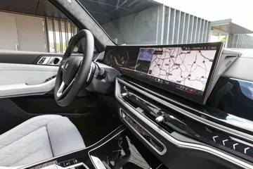 Vista de la consola central y volante del BMW X5, destacando su tecnología avanzada.