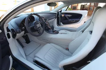 Interior de cuero blanco del Bugatti Veyron, mostrando asientos y volante.
