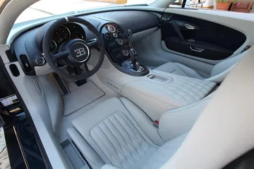 Vista lateral del lujoso interior del Bugatti Veyron, destacando su acabado y asientos deportivos.