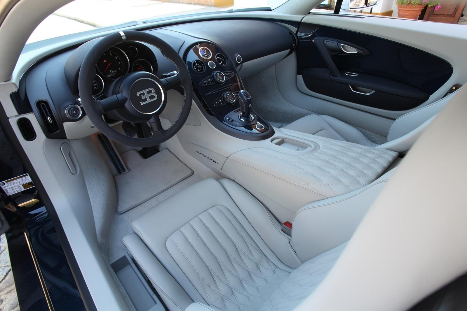 Vista lateral del lujoso interior del Bugatti Veyron, destacando su acabado y asientos deportivos.