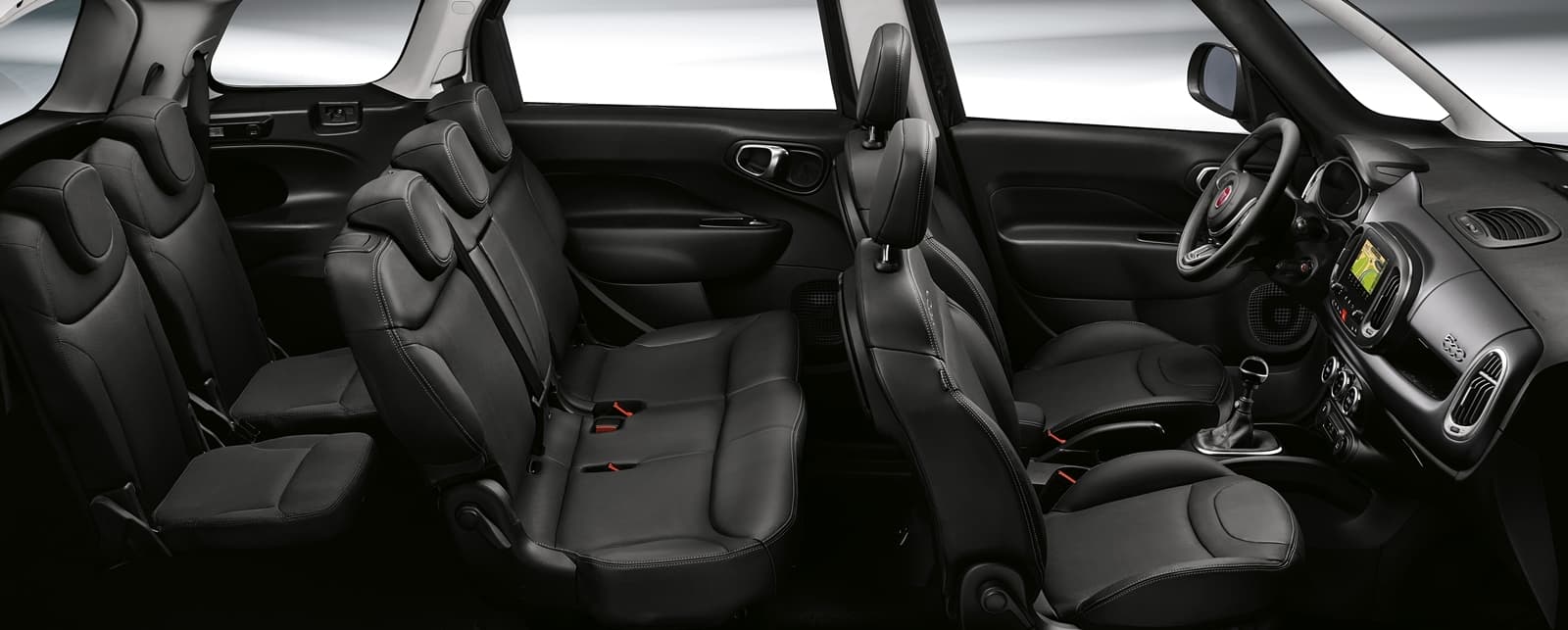 Vista del espacio y asientos traseros del Fiat 500L, destacando su amplitud.