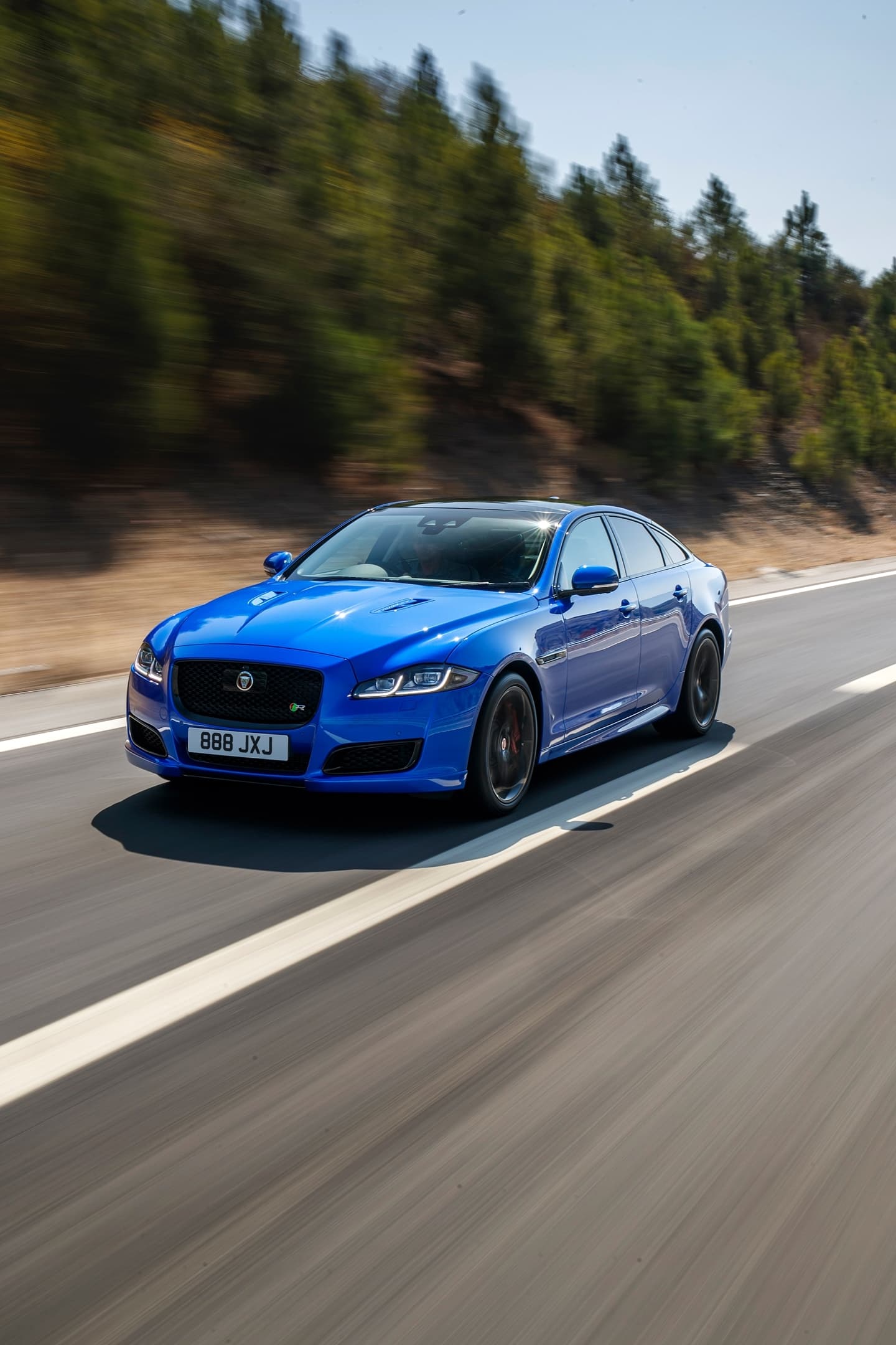 Vista dinámica del Jaguar XJ en carretera, destacando su diseño elegante