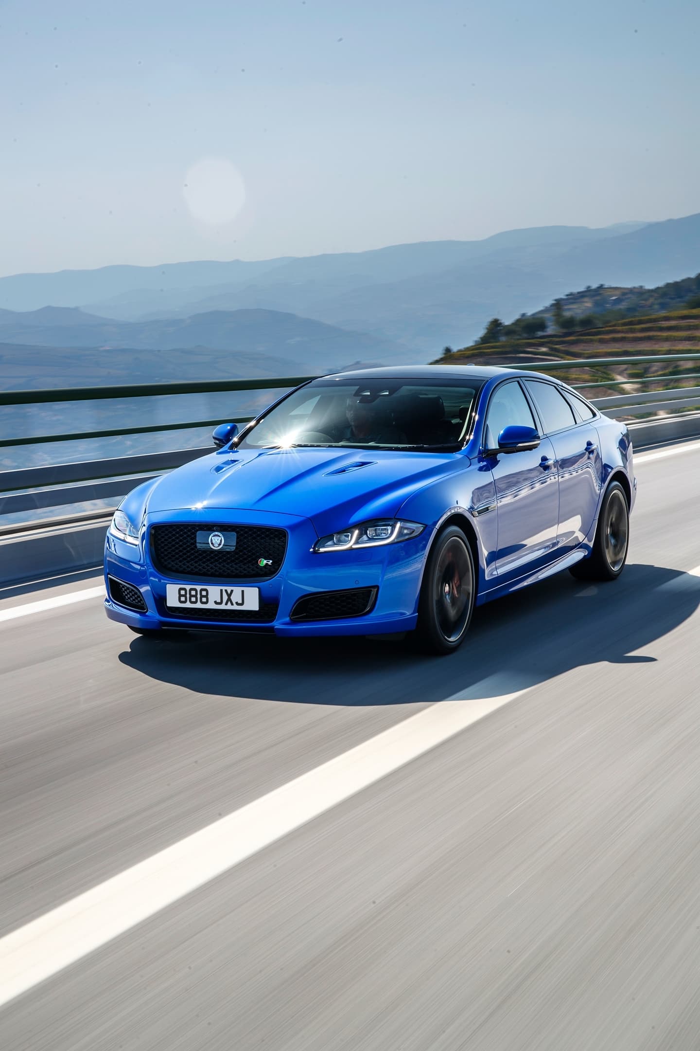 Vista dinámica del Jaguar XJ en color azul, destacando su diseño elegante.