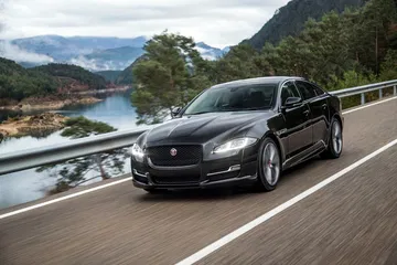 Vista dinámica del Jaguar XJ durante conducción cerca de un lago.