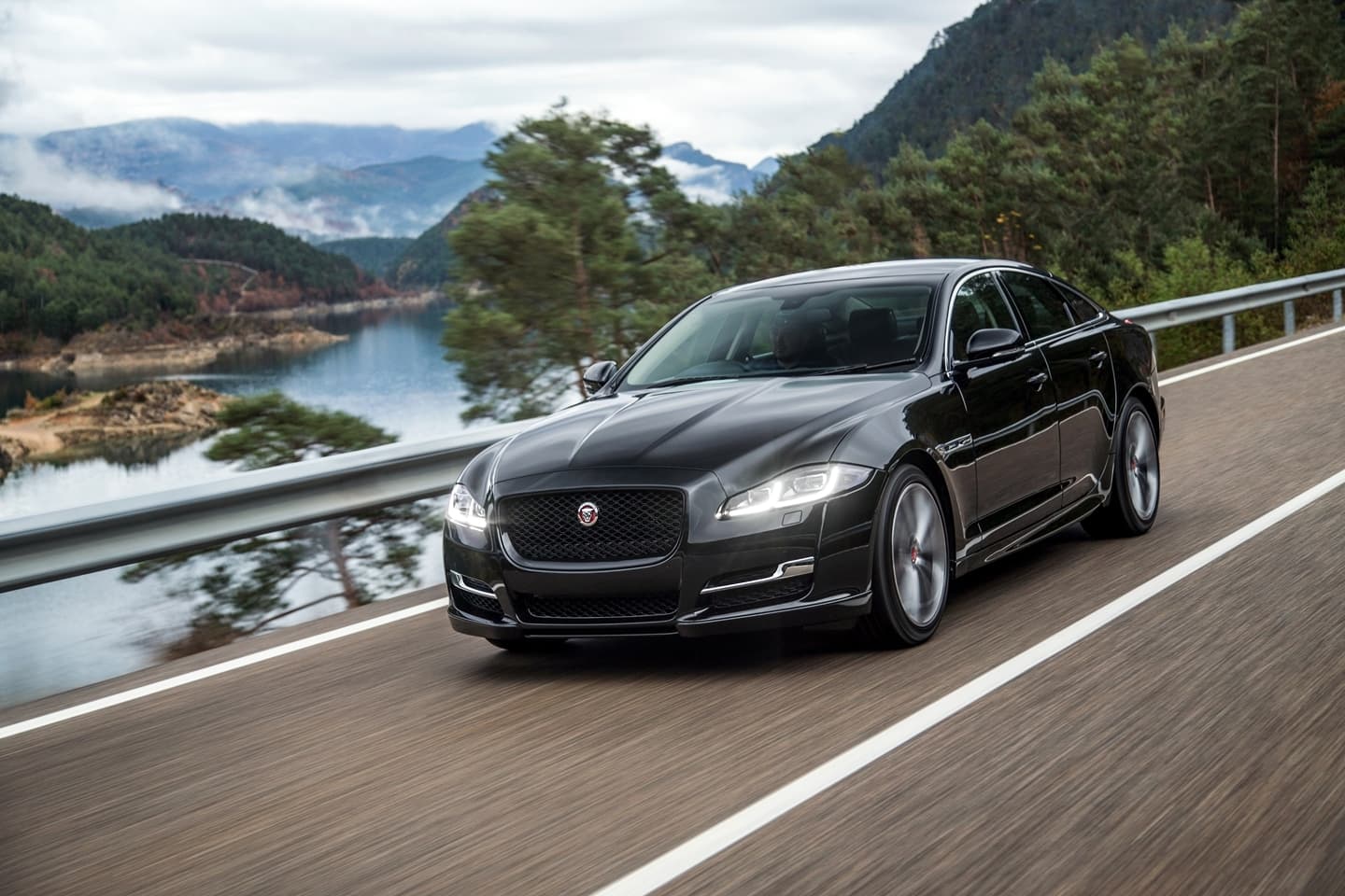 Vista dinámica del Jaguar XJ durante conducción cerca de un lago.