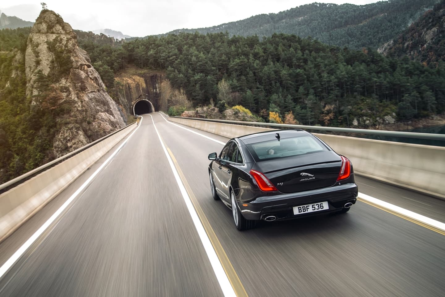 Vista dinámica del Jaguar XJ mientras recorre una carretera de montaña