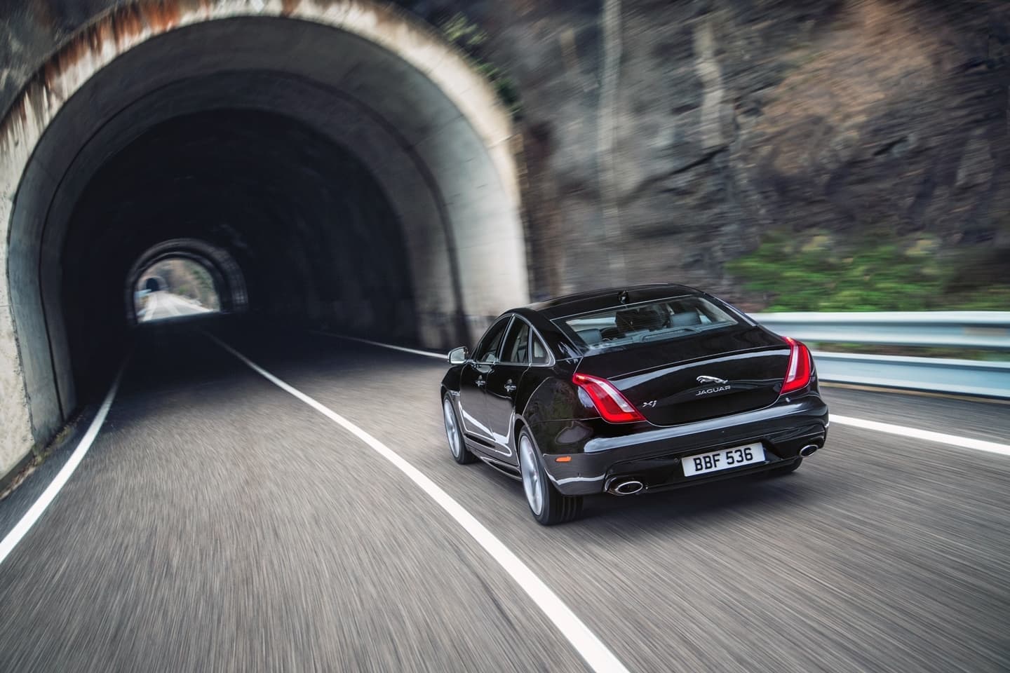 Vista dinámica del Jaguar XJ saliendo de un túnel, mostrando líneas elegantes.