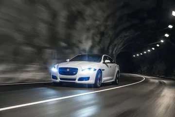 Jaguar XJ en movimiento, mostrando su elegante perfil delantero y lateral.