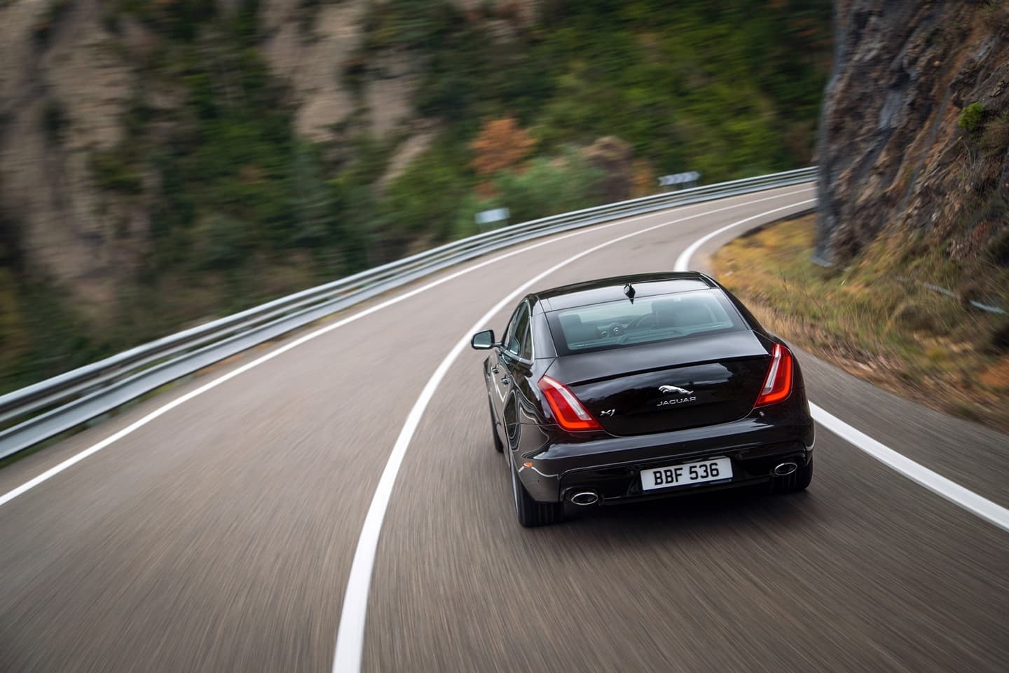 Vista dinámica del Jaguar XJ evidenciando su elegante línea trasera y lateral.