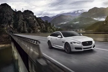 Vista lateral del Jaguar XJ en movimiento, destacando su diseño aerodinámico.