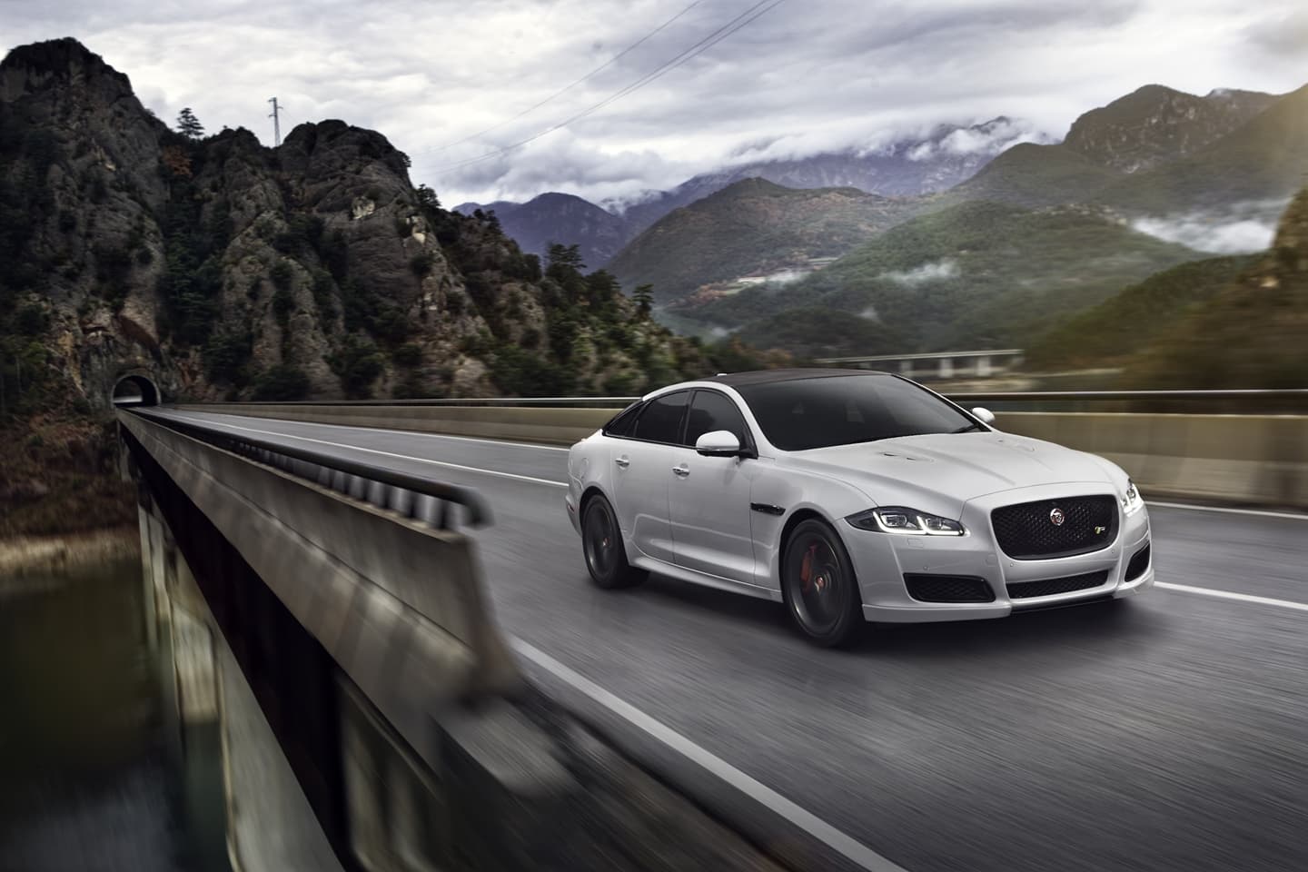 Vista lateral del Jaguar XJ en movimiento, destacando su diseño aerodinámico.
