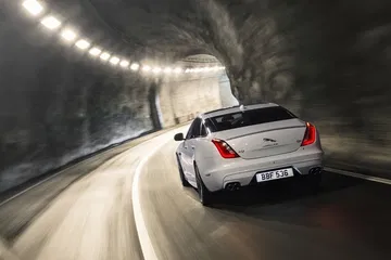 Vista trasera del Jaguar XJ demostrando su elegancia y dinamismo en un túnel.