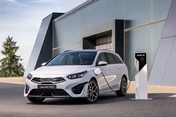 Kia Ceed enchufado en estación de carga, mostrando su perfil delantero y lateral.