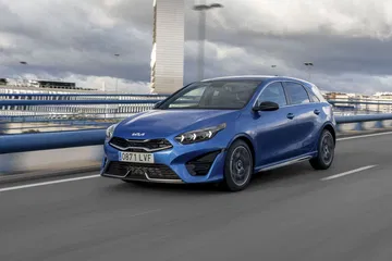 Vista dinámica del Kia Ceed en un entorno urbano, destacando su diseño frontal y lateral.