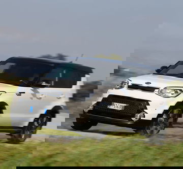 Vista dinámica del Kia e-Soul en movimiento, destacando su diseño lateral.