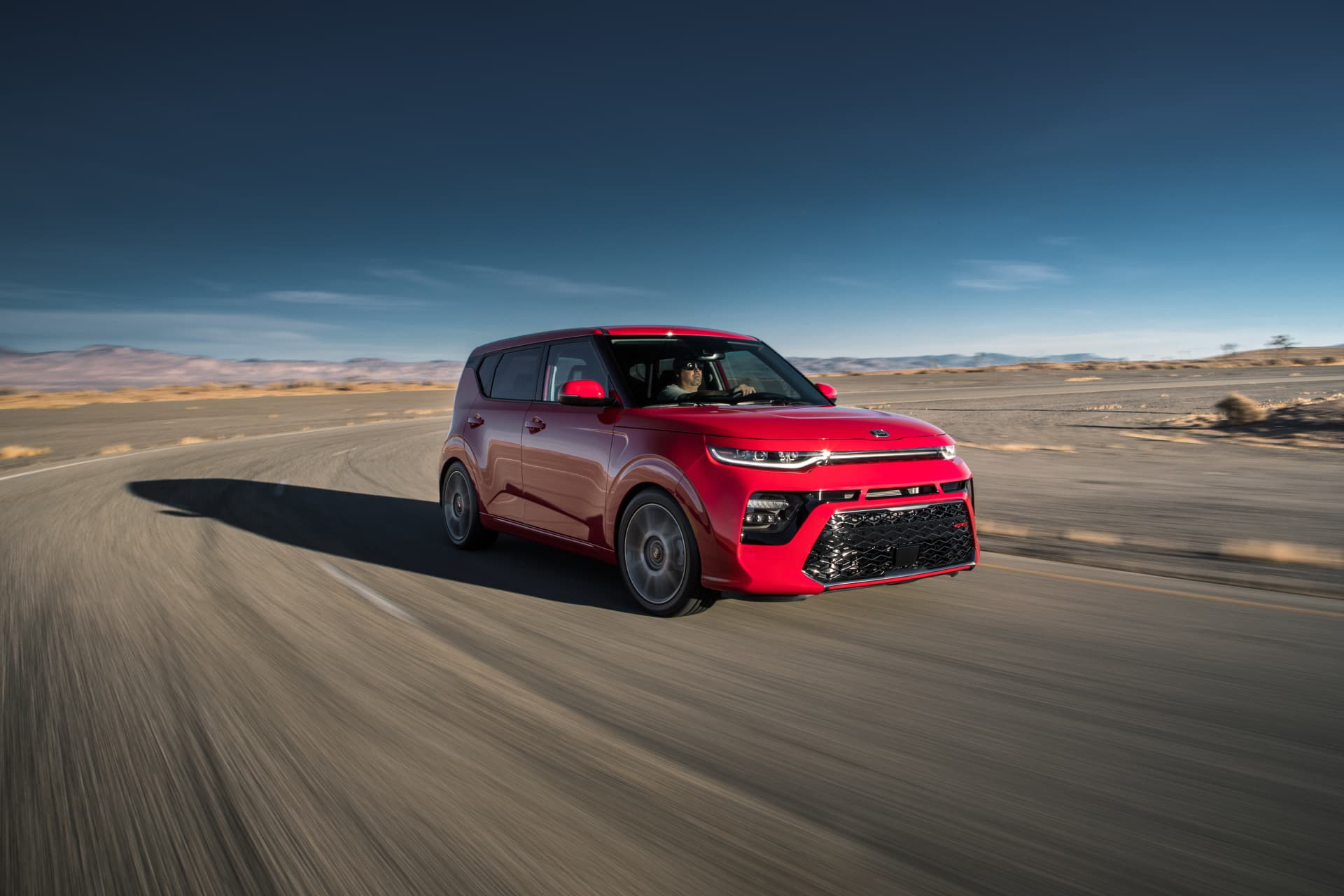 Vista dinámica del Kia e-Soul en movimiento, enfatizando su diseño lateral.