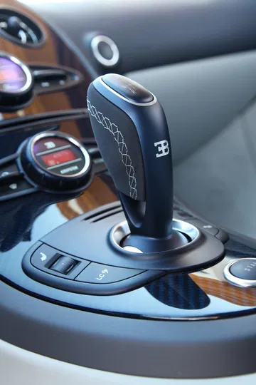 Vista cercana de la palanca de cambios de un Bugatti Veyron, acabado impecable.