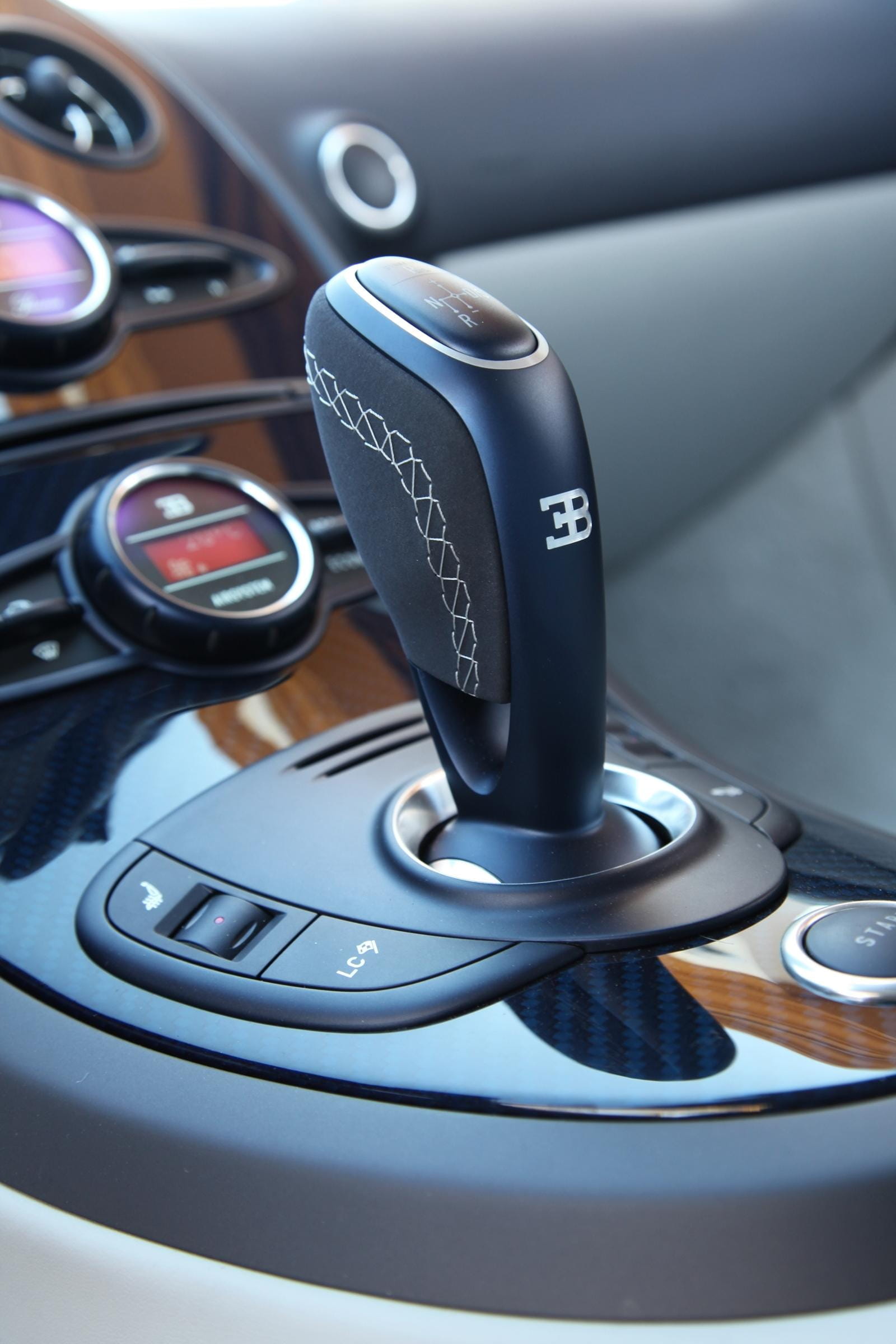 Vista cercana de la palanca de cambios de un Bugatti Veyron, acabado impecable.