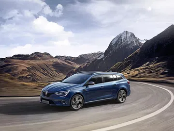 Vista dinámica del Renault Mégane en carretera de montaña, resaltando su diseño lateral