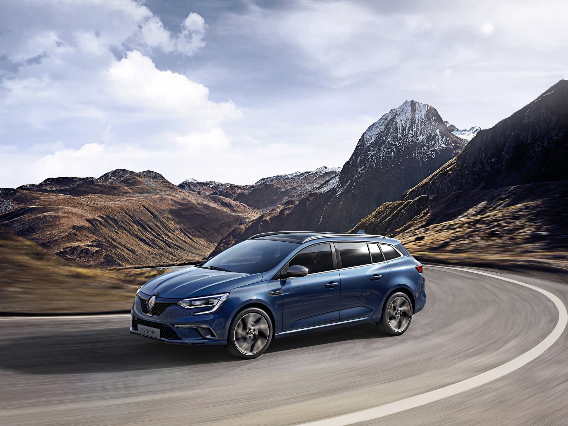 Vista dinámica del Renault Mégane en carretera de montaña, resaltando su diseño lateral