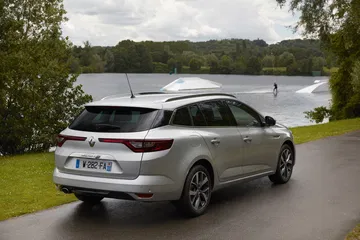 Vista trasera y lateral del Renault Mégane con un fondo de lago y vegetación.